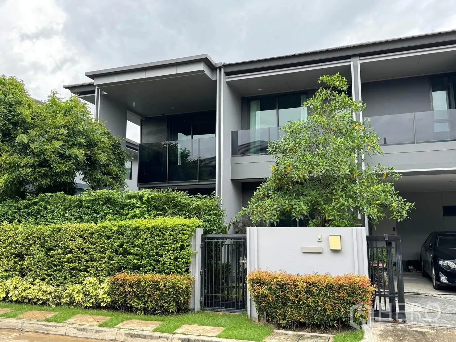 บ้านเดี่ยว for rent in Bang Kapi, Bangkok - ภายนอกบ้านเดี่ยวสองชั้นสมัยใหม่ พร้อมระเบียง ประตูรั้ว และต้นไม้รอบบ้าน