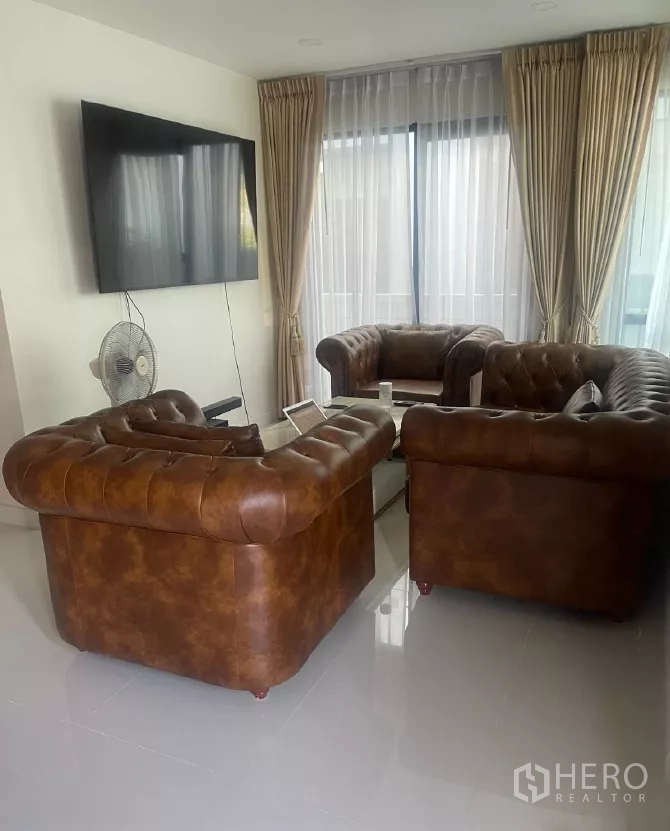 บ้าน ให้เช่าหรือขายในSaphan Sung, Bangkok - ห้องนั่งเล่นทีวีติดผนัง โซฟาเชสเตอร์ฟิลด์หันเข้าหากระจกบานเลื่อน