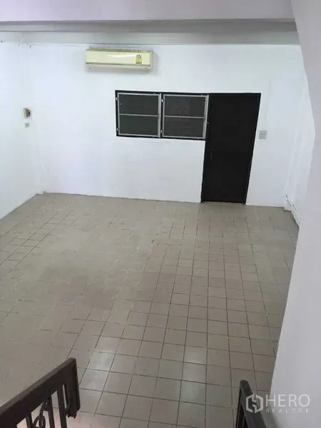 ทาวน์เฮาส์ ให้เช่าในPhra Khanong, Bangkok - พื้นที่นั่งเล่นปูกระเบื้องกว้าง มีแอร์ผนัง ประตูและหน้าต่างสีดำ