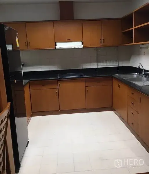 คอนโด ให้เช่าในWatthana, Bangkok - ครัวรูปตัว U ตู้ไม้ ท็อปหินสีดำ พร้อมเตา เครื่องดูดควัน และอ่างล้างจาน