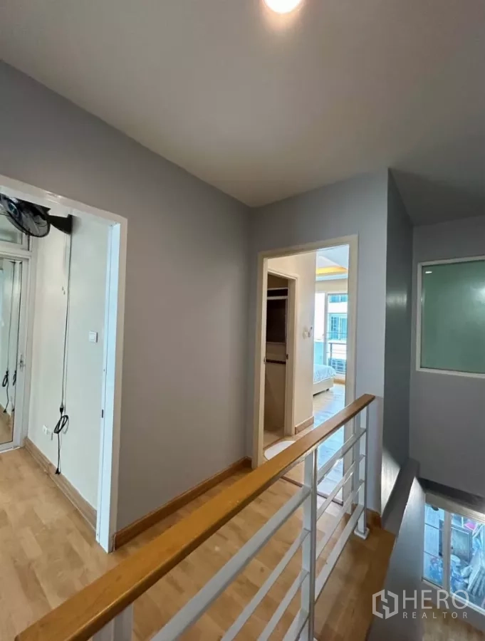 Townhouse for rent in Wang Thonglang, Bangkok - Upstairs landing with wood flooring and white handrail leading to bedrooms