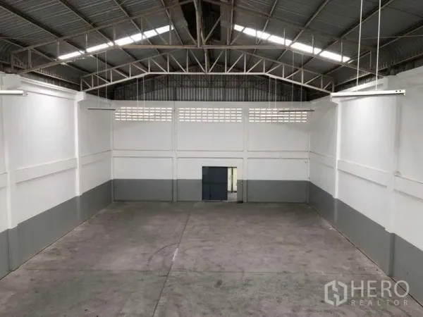 Factory for rent in Khlong Luang, Pathum Thani - Spacious high-ceiling warehouse bay with a steel truss roof and smooth concrete floor.