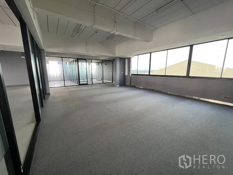 Office Space for rent in Mueang Samut Prakan, Samut Prakan - Carpeted office room with full-height windows next to a glass meeting room.
