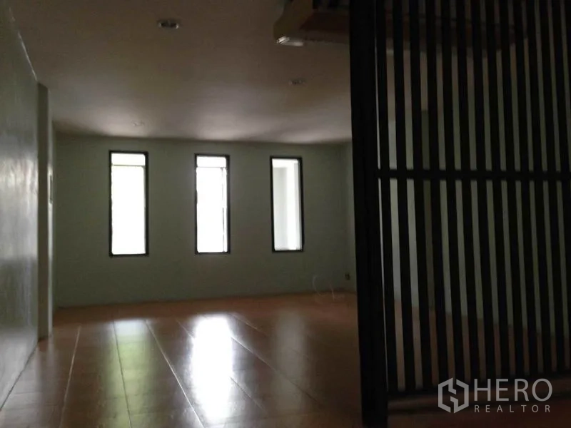 Home Office for rent or sale in Wang Thonglang, Bangkok - Open room with three narrow windows, light tile flooring, and a black slatted divider in a Bangkok home office.