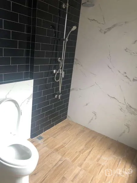 Home Office for rent or sale - Contemporary bathroom with black subway tiles, marble-look wall, rain shower and light wood floor.