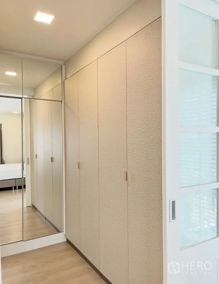 Detached House for rent in Bang Phli, Samut Prakan - Walk-in closet corridor with full-height wardrobes and a mirrored panel.