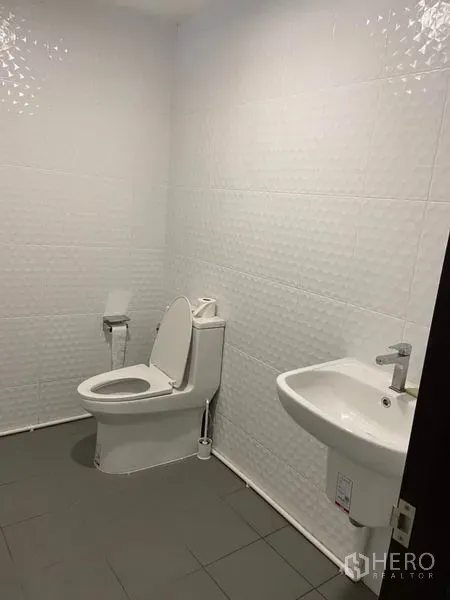 ทาวน์เฮาส์ ให้เช่าในKhlong Toei, Bangkok - ห้องน้ำมินิมอลผนังกระเบื้องลอนสีขาว พร้อมโถสุขภัณฑ์ สายชำระ และอ่างล้างหน้าแขวนผนัง