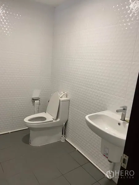 ทาวน์เฮาส์ ให้เช่าในKhlong Toei, Bangkok - ห้องน้ำมินิมอลผนังกระเบื้องลอนสีขาว พร้อมโถสุขภัณฑ์ สายชำระ และอ่างล้างหน้าแขวนผนัง