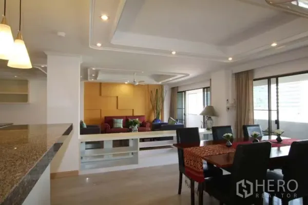 คอนโด ขายในWatthana, Bangkok - พื้นที่ทานอาหารโต๊ะหกที่นั่ง โคมไฟแขวน และทางออกสู่ระเบียง ข้างเคาน์เตอร์ครัวแบบเปิด