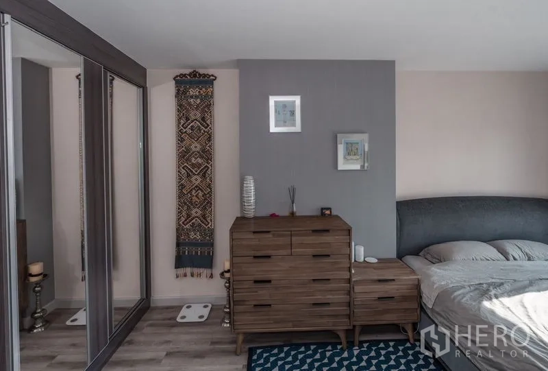 Condominium for rent in Sathon, Bangkok - Bedroom corner with dresser and floor-to-ceiling mirrored closets.