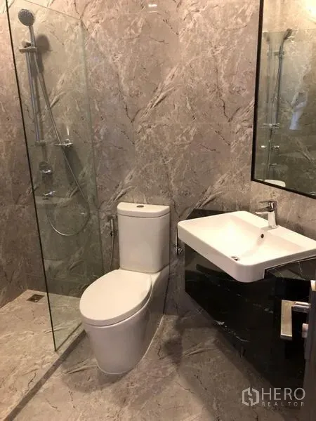 คอนโด ให้เช่าในWatthana, Bangkok - ห้องน้ำสไตล์โมเดิร์น กรุลายหินอ่อน พร้อมฝักบัวกั้นกระจก อ่างล้างหน้าและโถสุขภัณฑ์