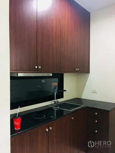 ทาวน์เฮาส์ ให้เช่าในYan Nawa, Bangkok - ครัวขนาดกะทัดรัด ตู้ไม้ เคาน์เตอร์หินสีดำ เตาไฟฟ้า และหน้าต่างกระจกยาว