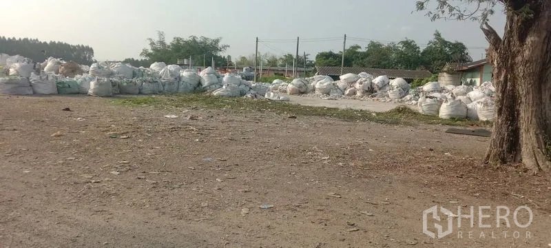 โรงงาน ขายในPhanat Nikhom, Chon Buri - พื้นที่เก็บกลางแจ้งวางถุงอุตสาหกรรมสีขาวจำนวนมากบนพื้นกรวด.