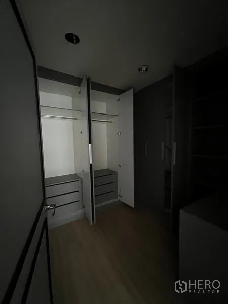 店屋 出租在Watthana, Bangkok - 步入式衣柜，内置柜体与层架，光线较暗。