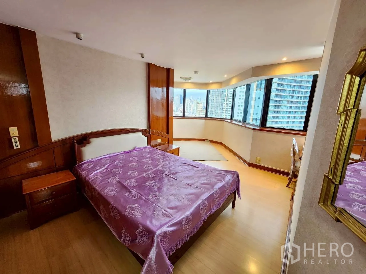 คอนโด ให้เช่าในKhlong Toei, Bangkok - ห้องนอนใหญ่พร้อมหน้าต่างมุมกว้าง โทนไม้ และวิวสกายไลน์กรุงเทพฯ