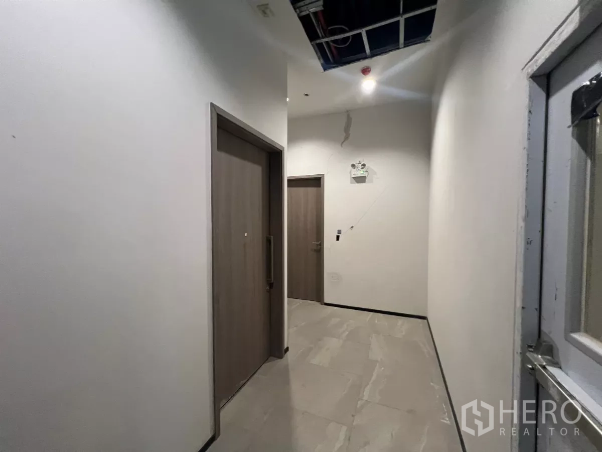 零售空间 出租 - 后勤走道，铺设瓷砖地面，通向储物间或卫生间门。