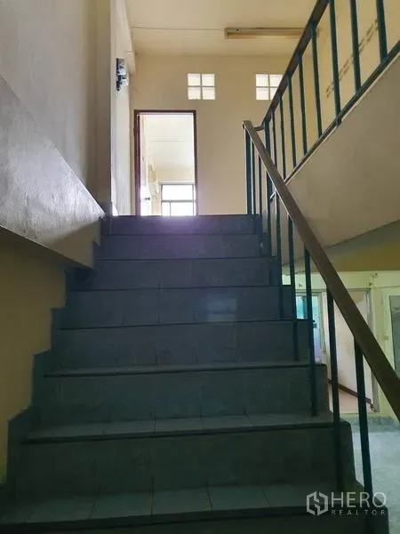 Shophouse for rent in Bang Rak, Bangkok - Internal staircase with blue handrail leading from the shop floor to upper levels.
