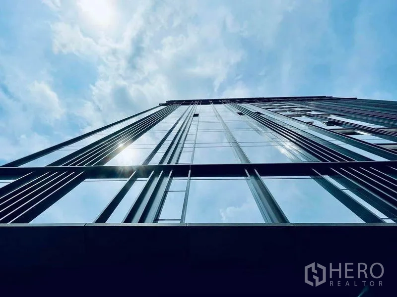 คอนโด ขายในPathum Wan, Bangkok - ซุ้มกระจกอาคารคอนโดสูง มุมมองแหงนขึ้นสู่ท้องฟ้าสีฟ้า