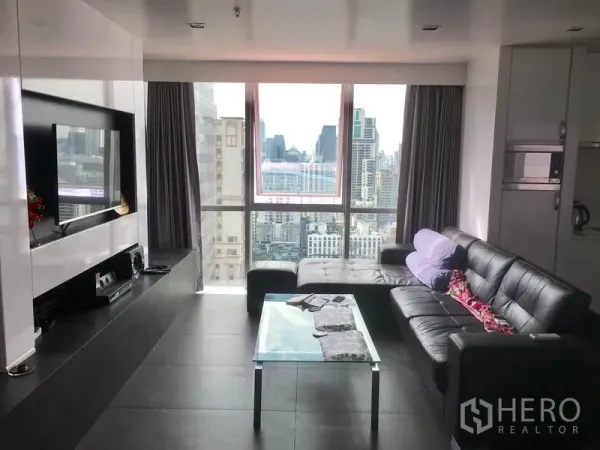 คอนโด ให้เช่าในWatthana, Bangkok - ห้องนั่งเล่นสไตล์โมเดิร์น โซฟาหนัง โต๊ะกระจก และกระจกบานใหญ่ชมวิวเมืองกรุงเทพฯ