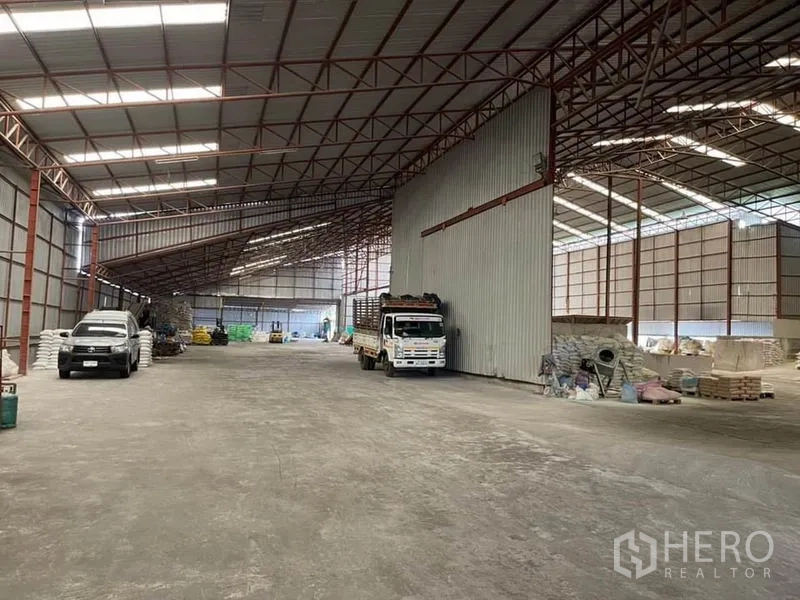 货栈 出售在Lam Luk Ka, Pathum Thani - 中央仓段，卡车停靠在高金属墙旁，回转空间充裕。