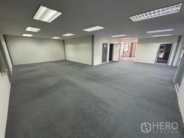 Office Space for rent - Large open-plan office floor with carpet and bright fluorescent lighting.