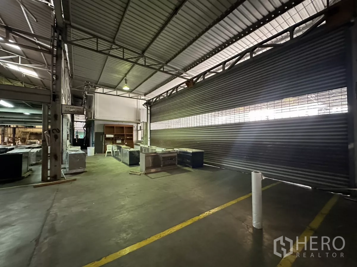 Warehouse for rent in Yan Nawa, Bangkok - Half-open roller shutter along the loading bay inside the warehouse.