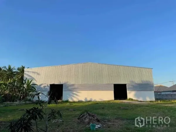 คลังสินค้า ขายในChon Buri - อาคารโกดังเมทัลชีทขนาดใหญ่ มีช่องประตูหลายจุดและสนามหญ้า ใต้ท้องฟ้าโปร่ง