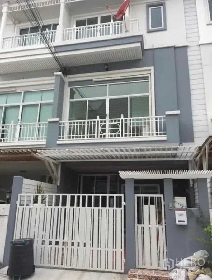 联排别墅 出租在Prawet, Bangkok - 现代多层联排别墅外立面，白色金属大门与阳台。