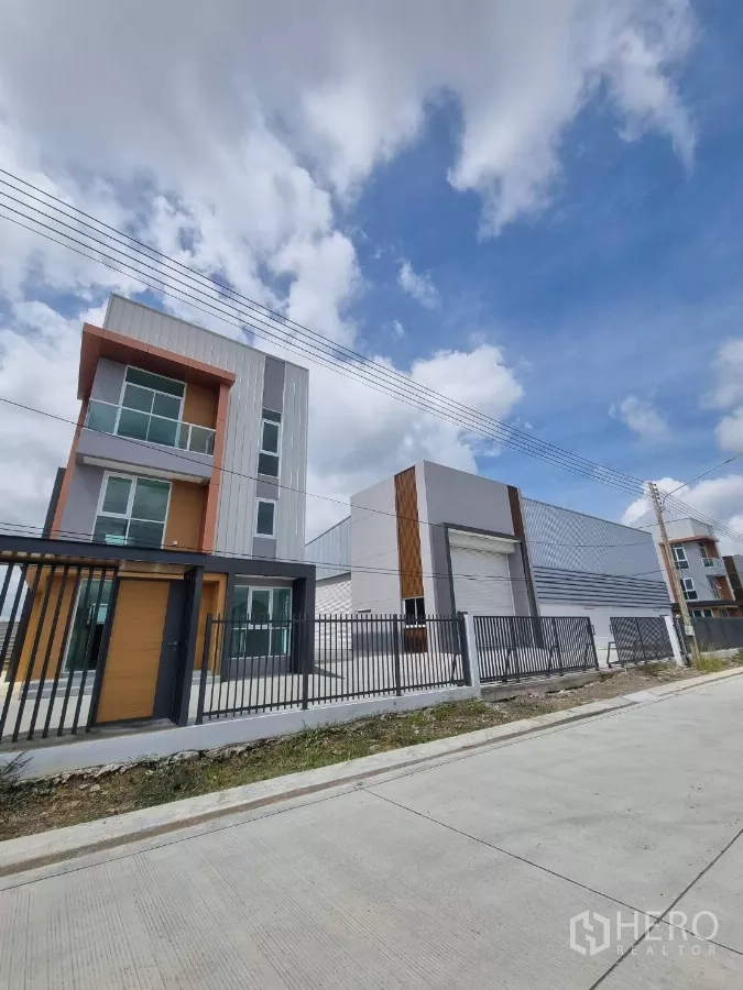 คลังสินค้า ขายในLam Luk Ka, Pathum Thani - ทิวทัศน์ริมถนนเห็นอาคารออฟฟิศและโกดังที่อยู่ด้านหลังรั้ว