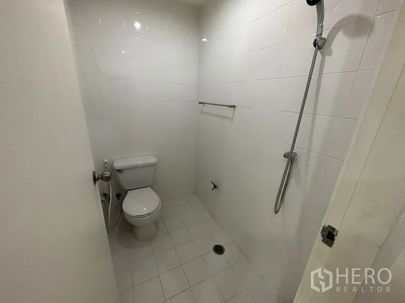 คอนโด ให้เช่าในWatthana, Bangkok - ห้องน้ำขนาดเล็กปูกระเบื้องสีขาว มีฝักบัวและโถสุขภัณฑ์