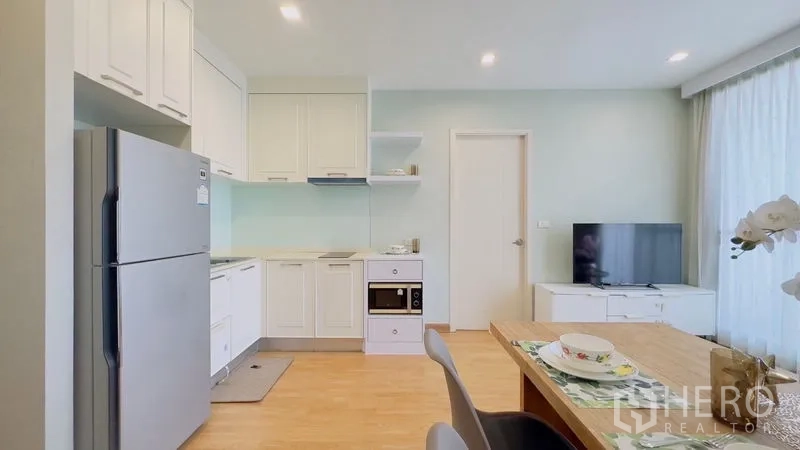 คอนโด ให้เช่าในWatthana, Bangkok - ครัวสีขาวกะทัดรัด ตู้เก็บของ เตา อบ ไมโครเวฟ ตู้เย็นสแตนเลส และโซนทีวี