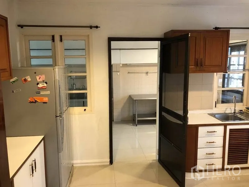 Detached House for rent - Fitted Western kitchen with wooden cabinets and sink, opening to a separate Thai kitchen.