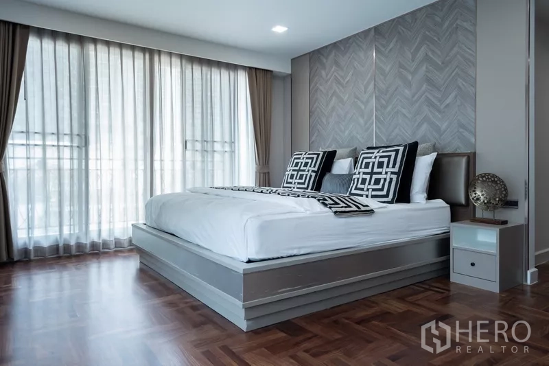 Apartment for rent - Master bedroom close-up showing platform bed and herringbone accent wall.