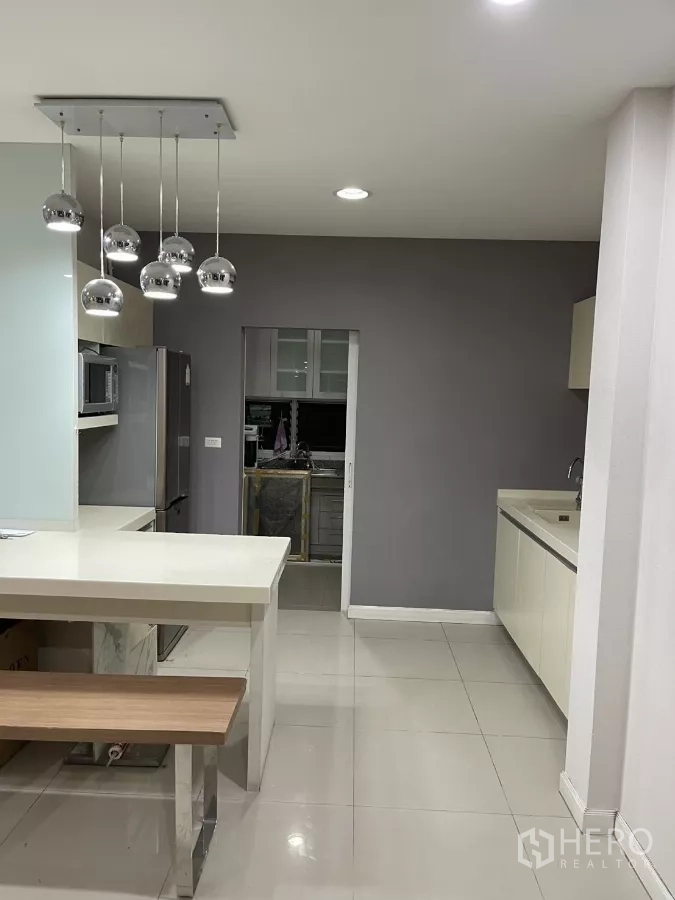 บ้าน ให้เช่าในBang Kapi, Bangkok - พื้นที่ครัวพร้อมไอส์แลนด์ ผนังเทา และทางเข้าครัวไทย