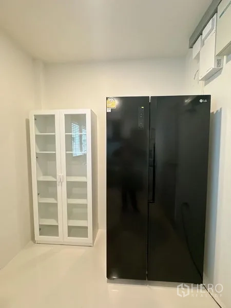 Detached House for rent or sale in Bang Phli, Samut Prakan - Utility pantry with black side-by-side refrigerator and glass-door cabinet.