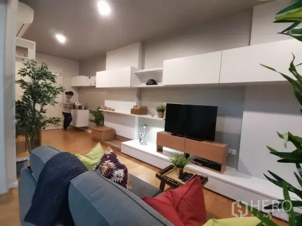 คอนโด ให้เช่าหรือขายในWatthana, Bangkok - ห้องนั่งเล่นโมเดิร์นพร้อมตู้ลอยสีขาว ชั้นวางทีวี และพื้นไม้