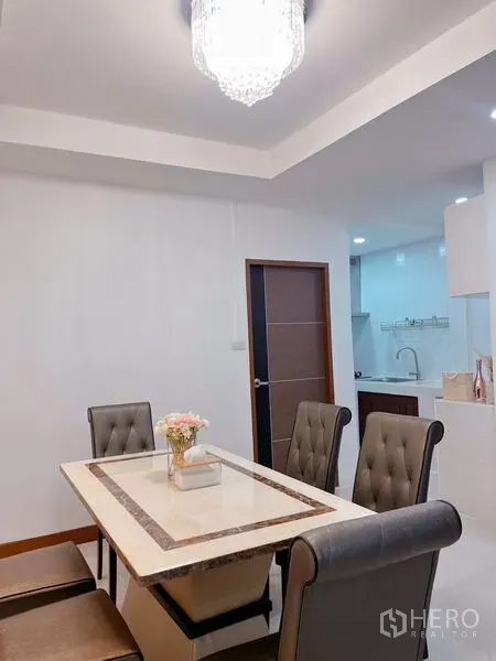 联排别墅 出租在Huai Khwang, Bangkok - 明亮的餐厅，配大理石餐桌、软包餐椅和水晶吊灯。