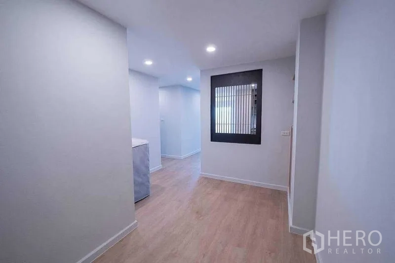 คอนโด ขายในChatuchak, Bangkok - โถงทางเดินสว่าง พื้นไม้สีอ่อน ไฟฝังฝ้า พร้อมช่องกระจกกรอบดำภายใน