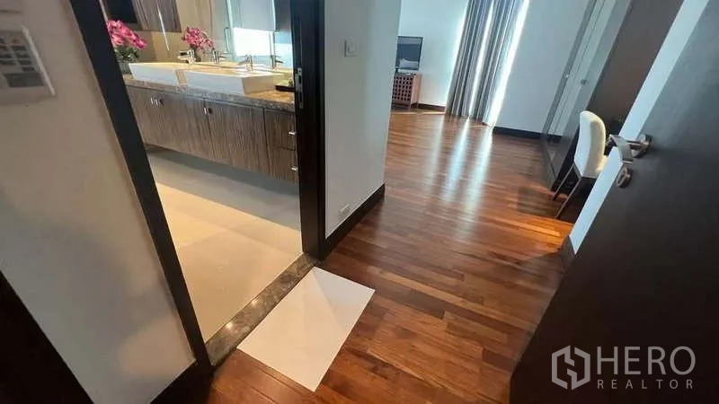 อพาร์ทเมนท์ ให้เช่าในPathum Wan, Bangkok - โถงทางเดินเชื่อมไปยังห้องน้ำอ่างล้างหน้าคู่และห้องนอนสว่าง พื้นไม้เงางาม