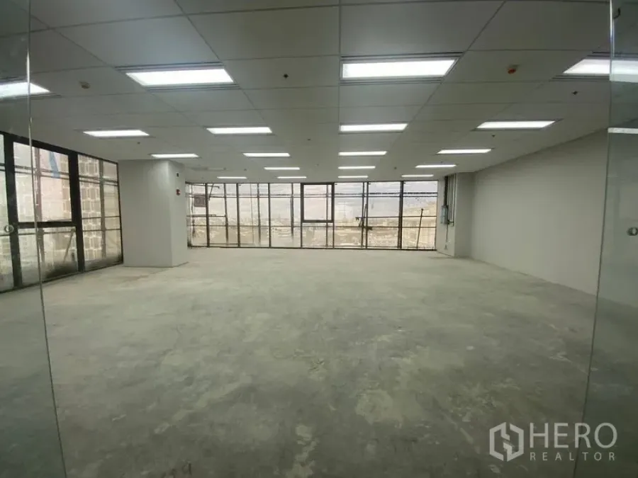 Office Space for rent - Empty office space with glass partitions, bright lighting and city-facing windows.