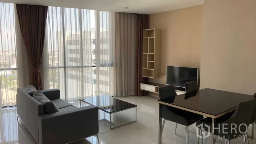 คอนโด ให้เช่าในWatthana, Bangkok - ห้องนั่งเล่นรับแสงธรรมชาติ หน้าต่างสูง โซฟา ชั้นวางทีวี ชั้นวางของ และชุดโต๊ะอาหาร 4 ที่นั่ง