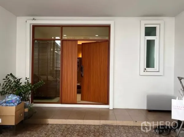 Townhouse for rent in Bang Kho Laem, Bangkok - Covered carport with vertical-slatted wooden double entry door and side window.