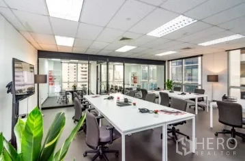 Office Space for rent in Khlong Toei, Bangkok - Bright open-plan office with white workstations, glass-partitioned meeting rooms, and city views.