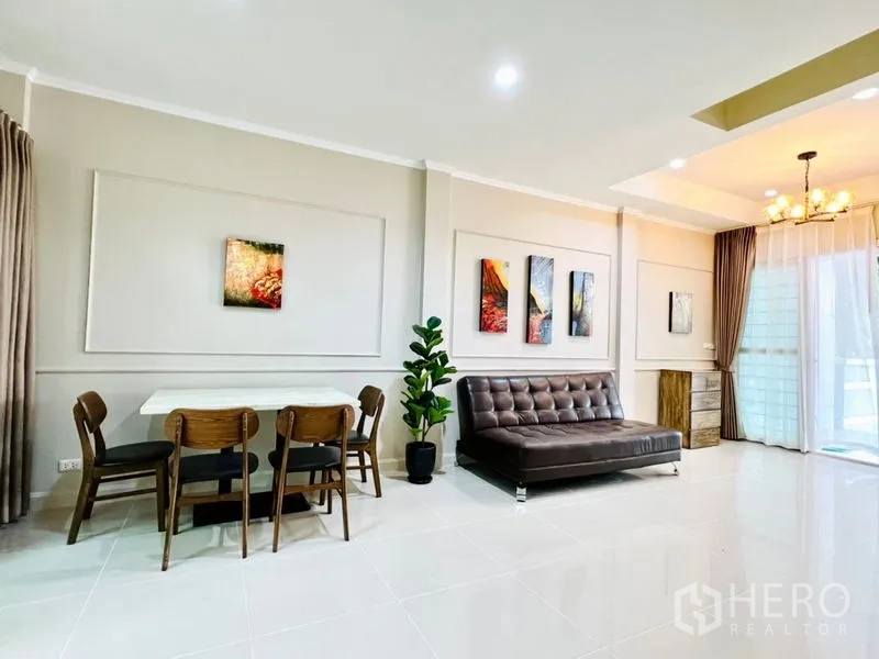 联排别墅 出租 - 宽敞的客餐一体空间，亮面地砖、沙发与纱帘通向露台。