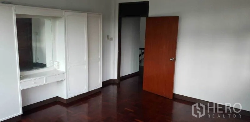 带办公室的家 出租在Chatuchak, Bangkok - 卧室配白色嵌入式衣柜与梳妆台，木地板。