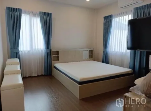 独立式住宅 出租 - 通透明亮的卧室，转角窗、蓝色窗帘与平台床。