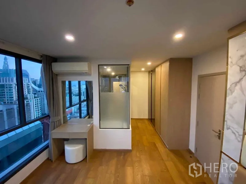 Condominium for rent or sale in Ratchathewi, Bangkok - Primary suite corridor with vanity, wardrobes and glass-partition shower area.