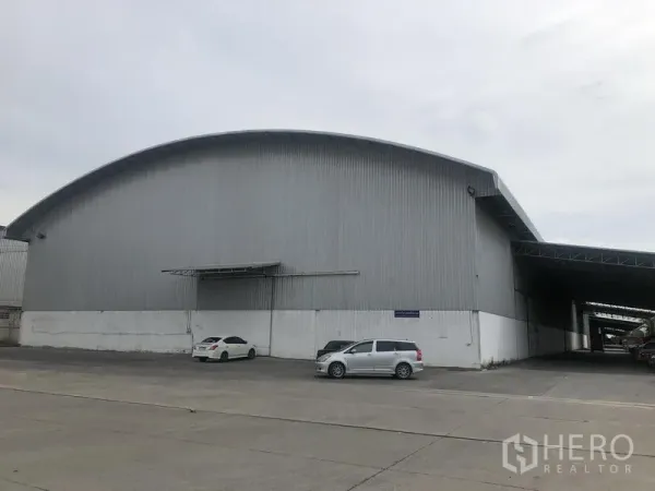 货栈 出租在Bang Pa-in, Phra Nakhon Si Ayutthaya - 金属外墙的大型仓库正面，拱形屋顶与宽阔混凝土场地。