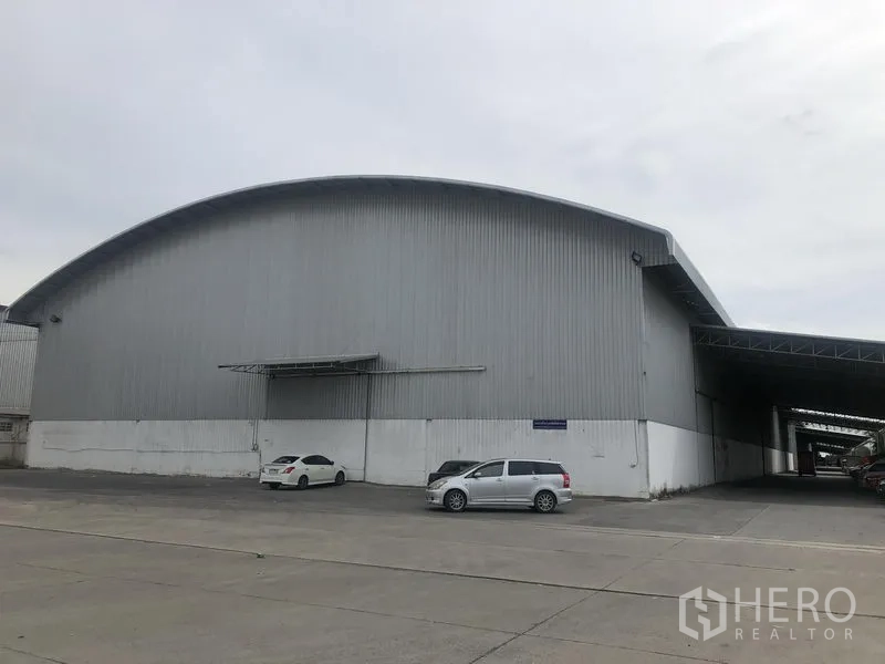 货栈 出租在Bang Pa-in, Phra Nakhon Si Ayutthaya - 金属外墙的大型仓库正面，拱形屋顶与宽阔混凝土场地。