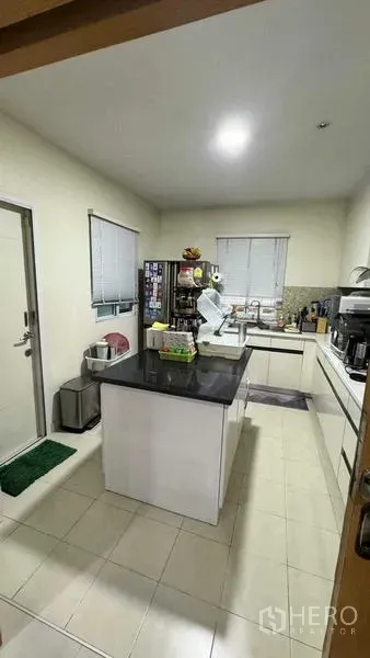 Detached House for sale in Suan Luang, Bangkok - Modern U-shaped kitchen with central island, stone countertop and ample cabinets.